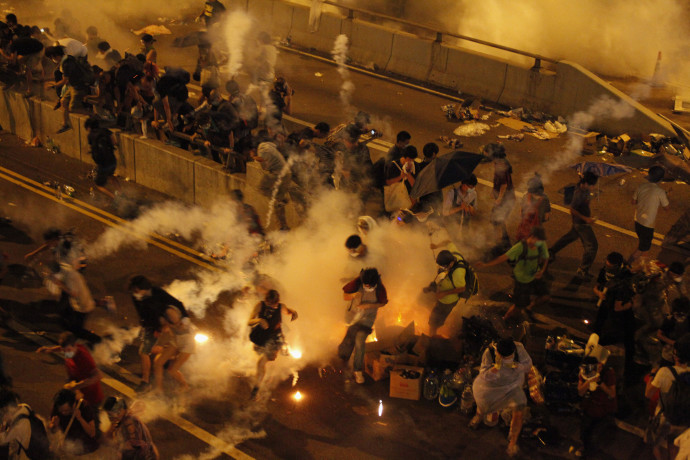 Riot police fire teargas to disperse protesters after thousands of demonstrators blocked the main street to the financial Central district outside the government headquarters in Hong Kong