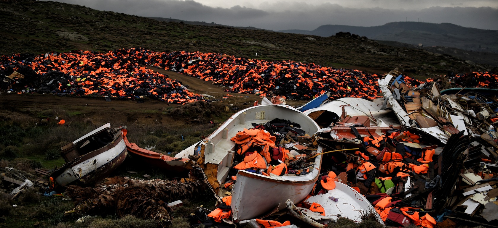 Wrecked boats and thousands of life jackets used by refugees and migrants during their journey across the Aegean sea lie in a dump in Mithimna on February 19, 2016. The EU and Turkey will hold a special summit in early March to push forward a deal to stem the migration crisis, European Council President Donald Tusk said. / AFP / ARIS MESSINIS